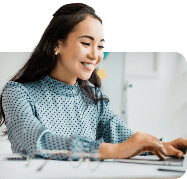 Woman smiling at laptop working on back office automation