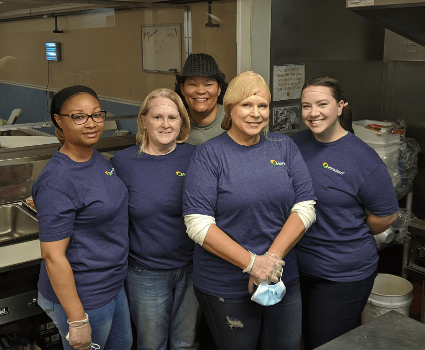 Group of 5 women wearing hair nets working at a nonprofit giving back and volunteering