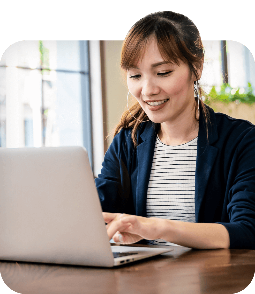 Woman smiling while typing on laptop offering customer support automation services