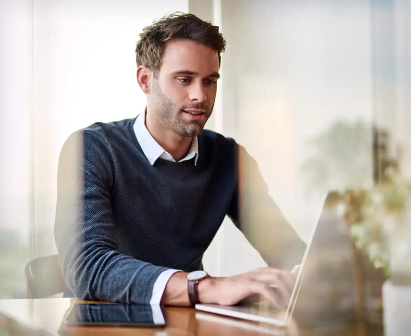 Business man typing on laptop computer looking at Automation in Contact Center Operations