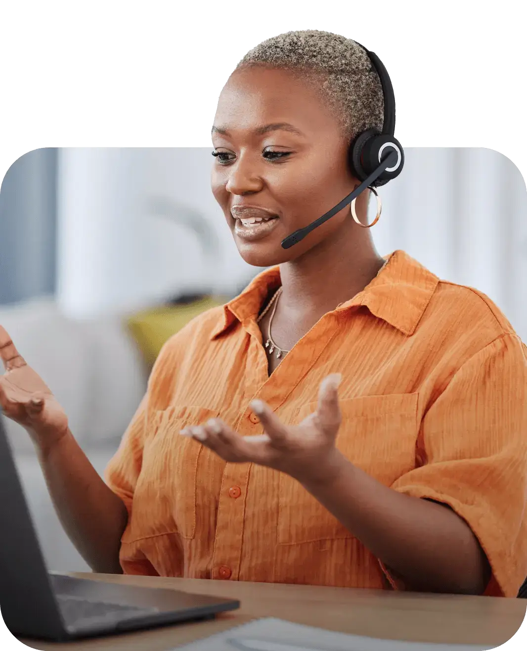 Woman talking on headset about contact center automation solutions while looking at laptop computer