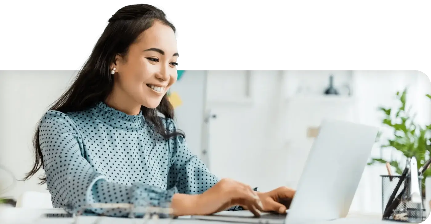 Woman smiling at laptop working on back office automation