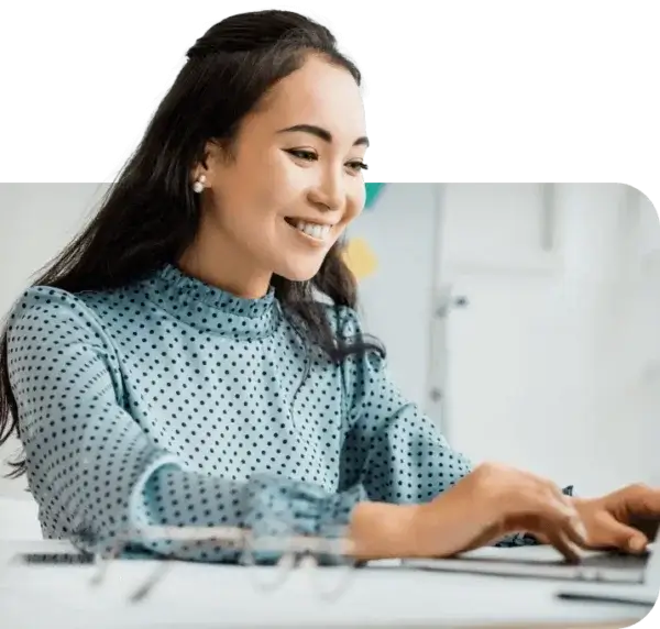 Woman smiling at laptop working on back office automation