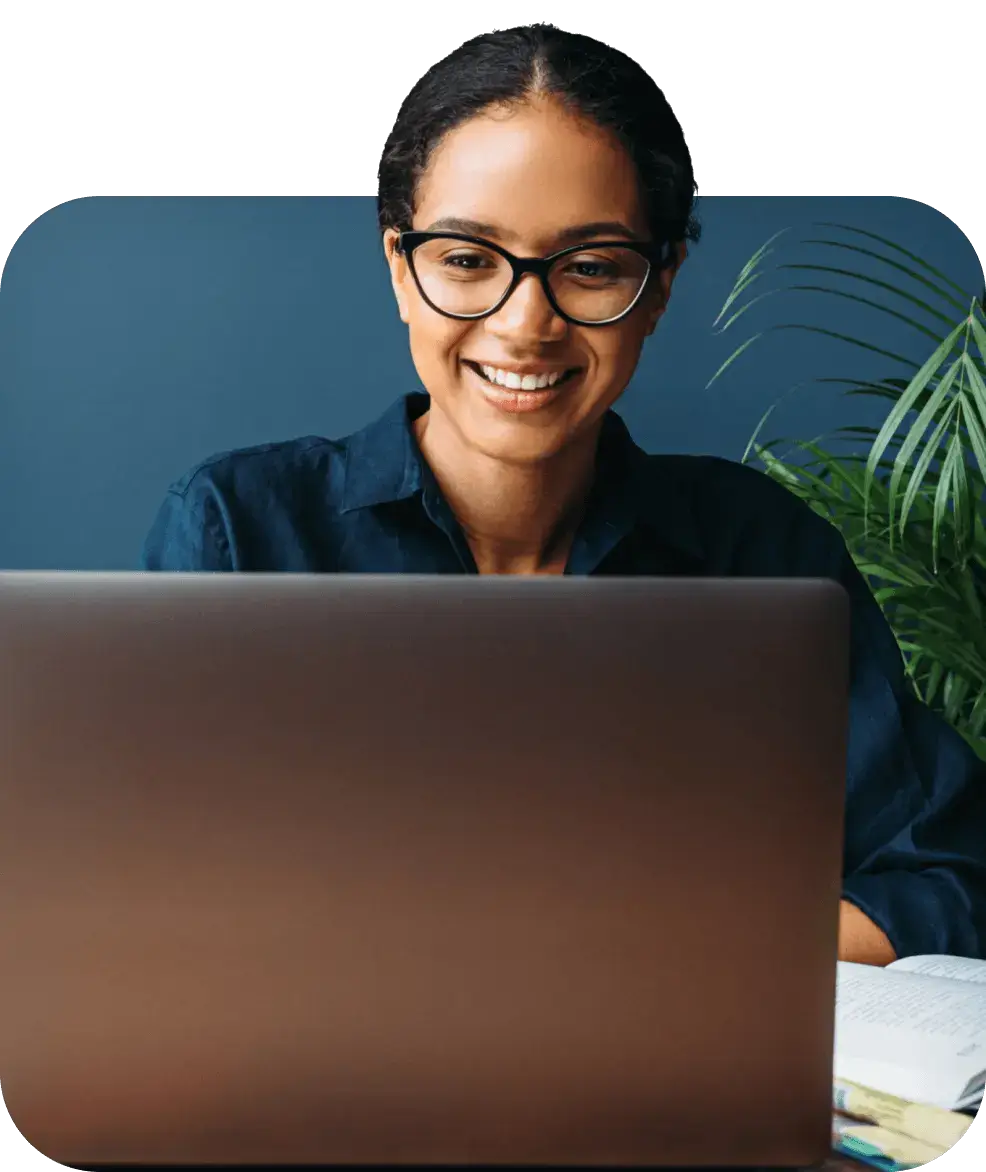 Woman wearing glasses looking at her laptop with back office automation solutions